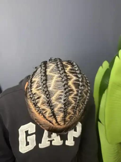 Men stitch braids with clean, straight scalp sections.